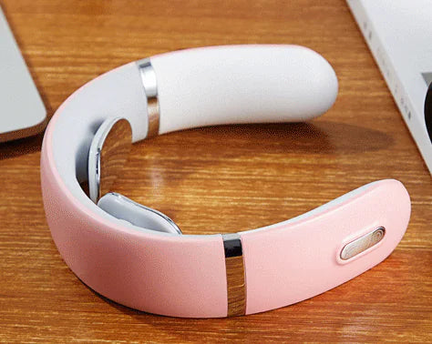 Pink cordless U-shaped neck massager on a desk